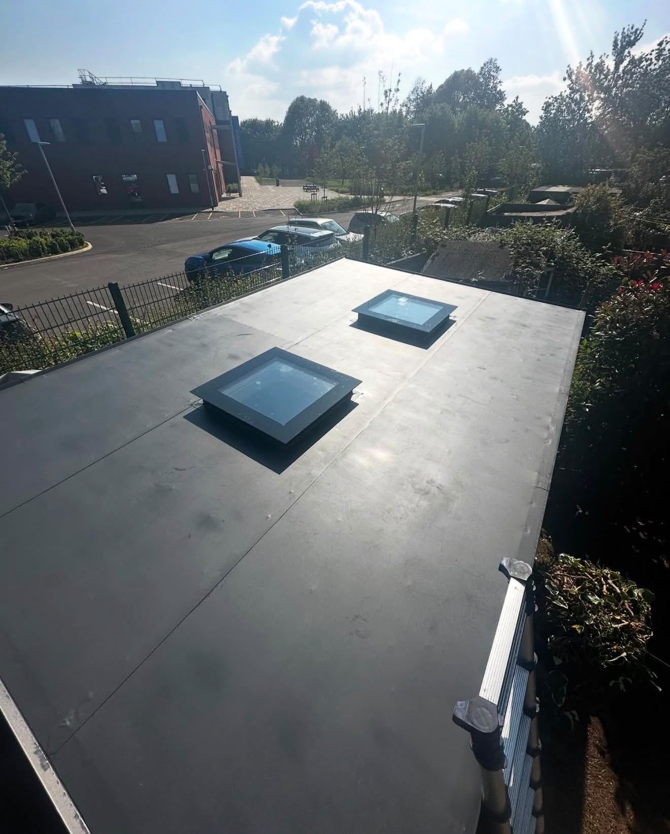 Two rooflights installed and weathered into a grey single-ply flat roof
