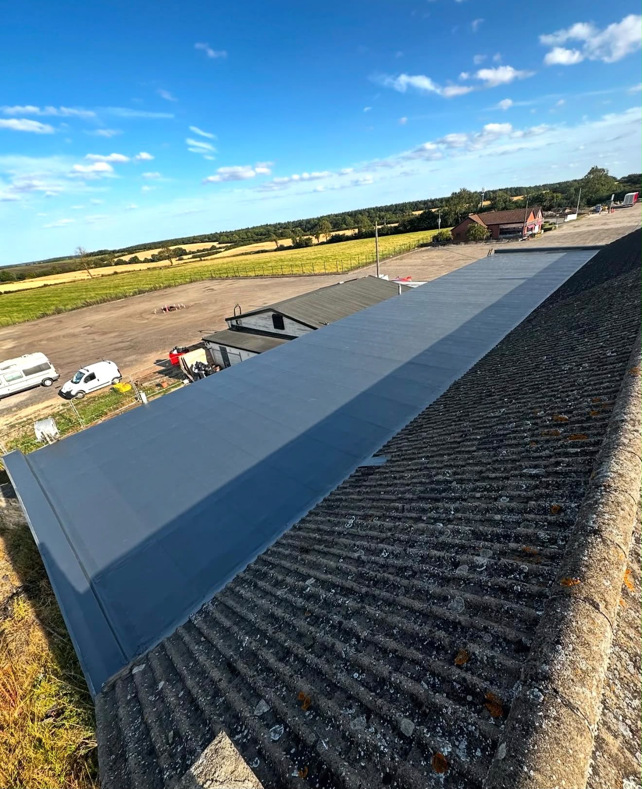 Photographic roof inspection view along a large grey flat roof