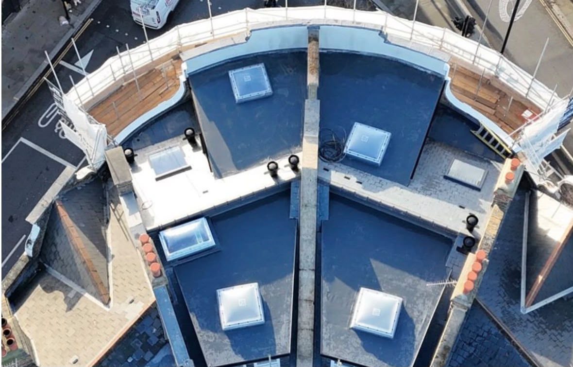 Aerial view of a curved commercial flat roof with rooflights in London